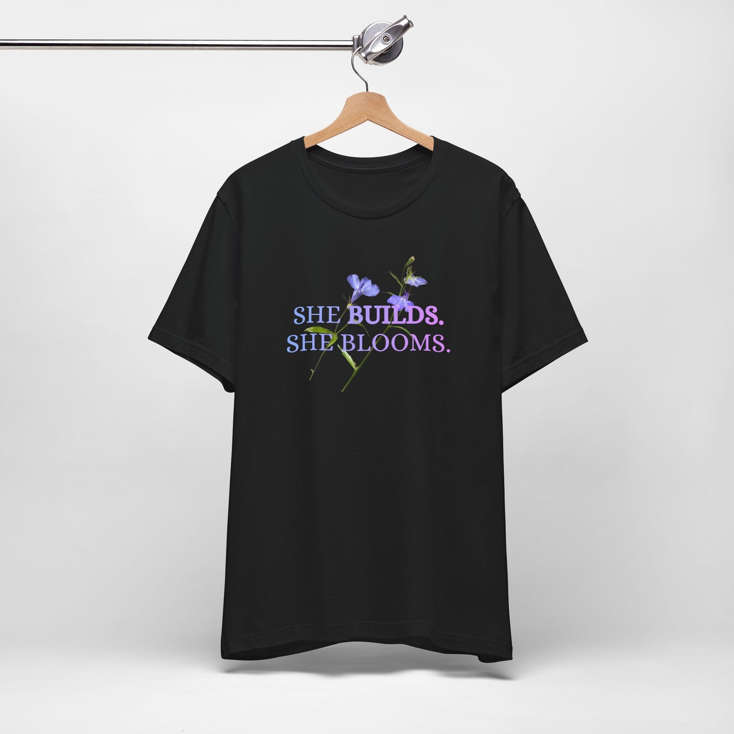 She Builds. She Blooms. - Women's Motivational Tee