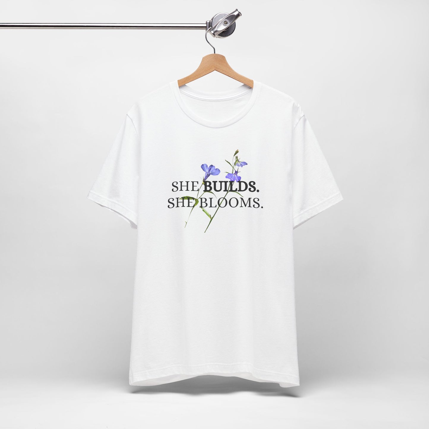She Builds. She Blooms. - Women's Motivational Tee