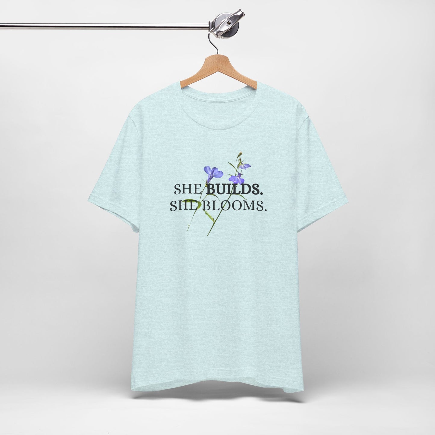She Builds. She Blooms. - Women's Motivational Tee