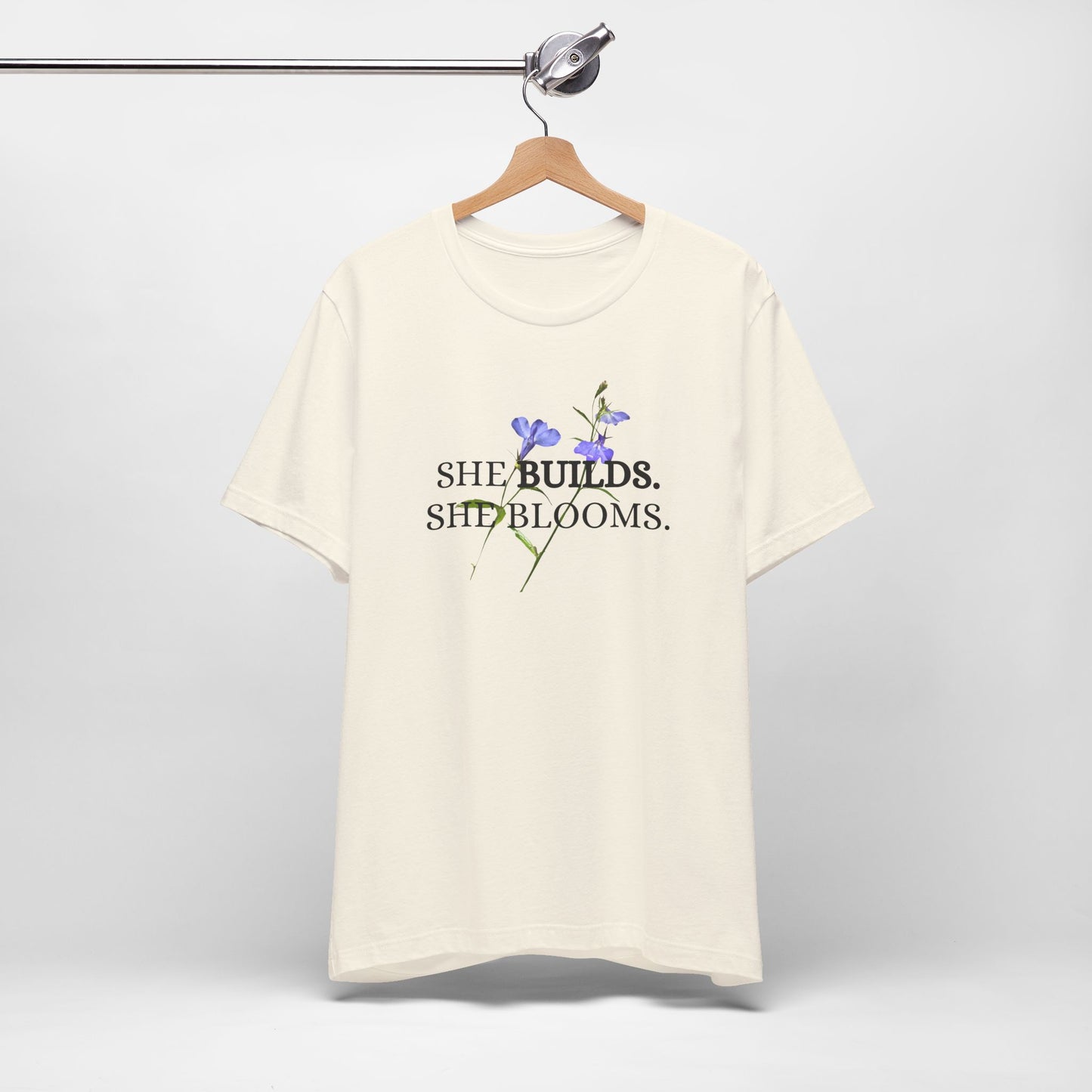 She Builds. She Blooms. - Women's Motivational Tee