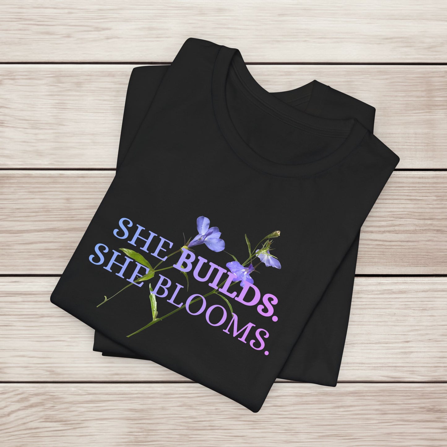 She Builds. She Blooms. - Women's Motivational Tee