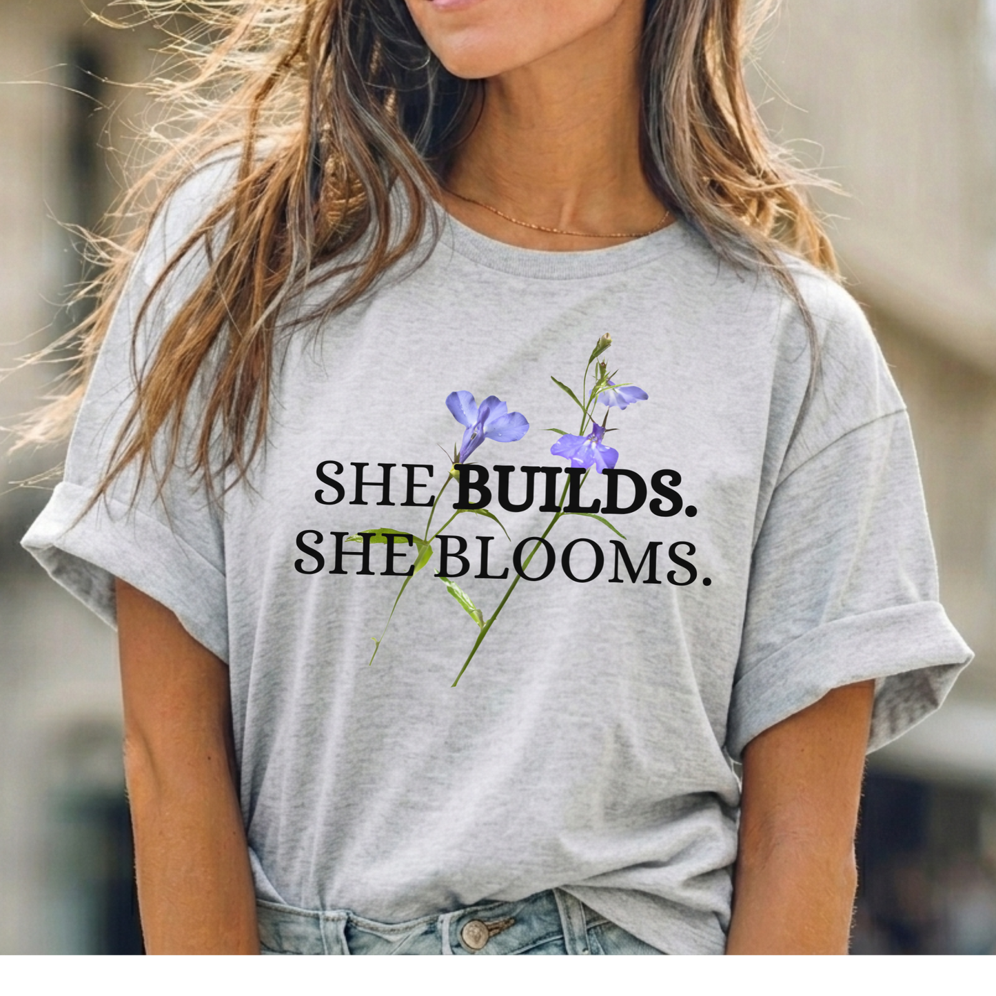 She Builds. She Blooms. - Women's Motivational Tee