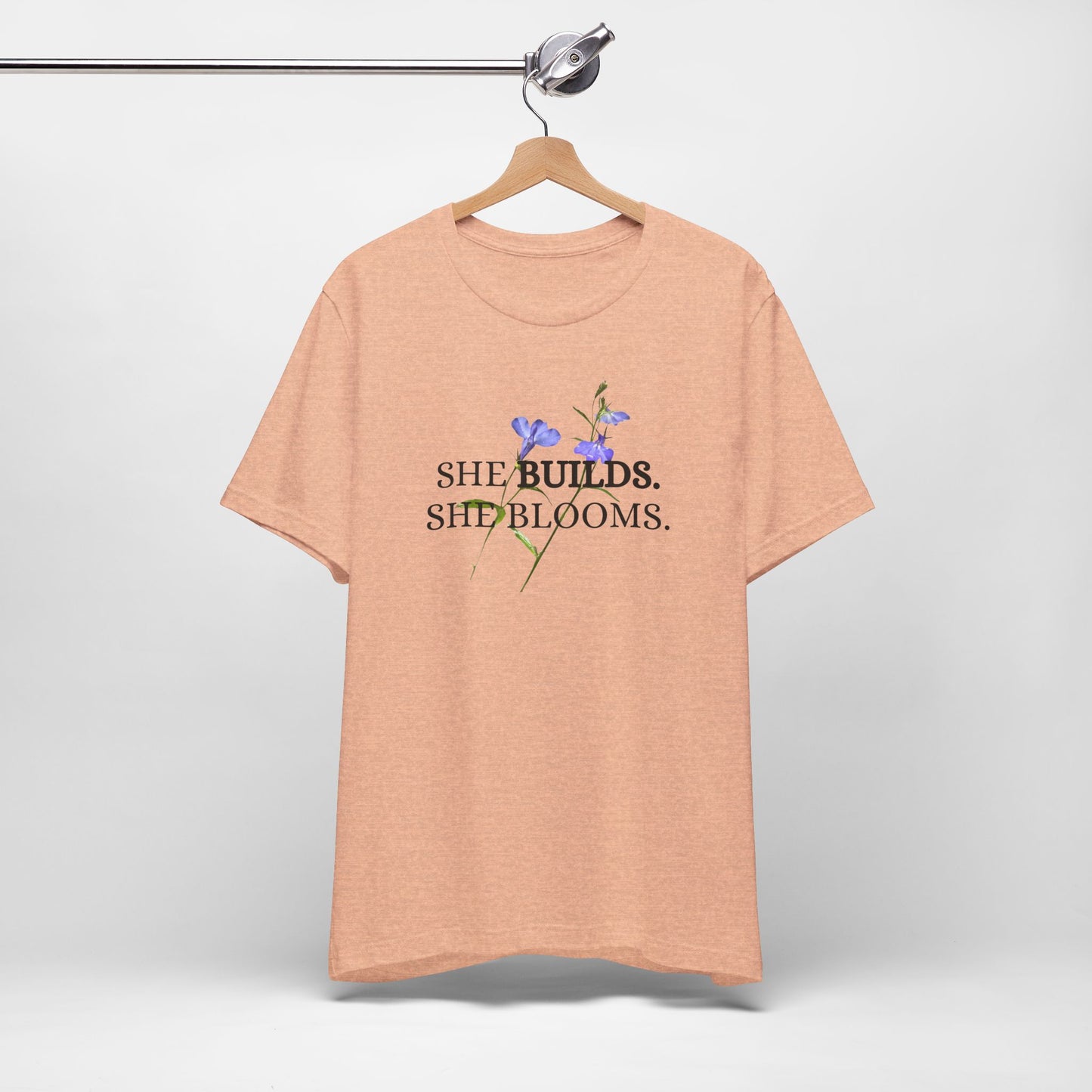 She Builds. She Blooms. - Women's Motivational Tee